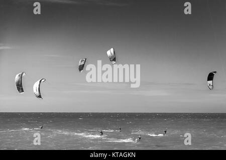 Cumbuco, Brésil, 9 juillet, 2017 : Noir et blanc coucher de soleil avec des kite surfeurs de profiter de la mer au soir Banque D'Images