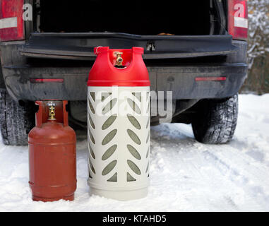 Bouteilles de gaz GPL sur la neige en face de la voiture ouverte boot, scène d'hiver Banque D'Images