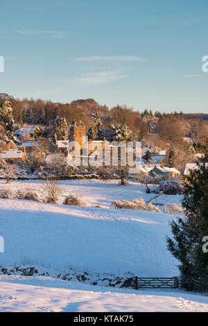 L'église Saint Laurent à Bourton On The Hill dans la neige au lever du soleil en décembre. Kingham Hill, Cotswolds, Gloucestershire, Angleterre. Banque D'Images