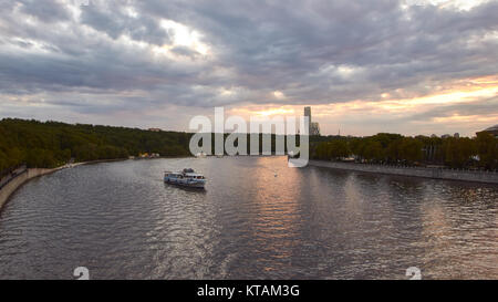 Cityscape au coucher du soleil avec le trafic de bateaux d'excursion sur la rivière au premier plan et arrière-plan nuages à coucher du soleil Banque D'Images
