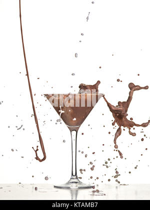 L'analyse macro avec le chocolat chaud de tomber dans le verre on white en studio Banque D'Images