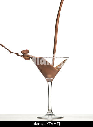 L'analyse macro avec le chocolat chaud de tomber dans le verre on white en studio Banque D'Images