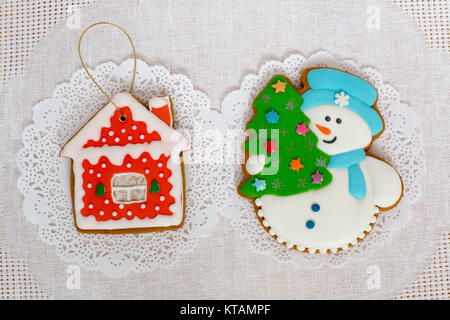 Deux gingerbread cookies en forme de l'arbre de Noël, bonhomme de neige et la petite maison sur un fond de serviette blanche. Haut de la vue, télévision lay, copy space Banque D'Images