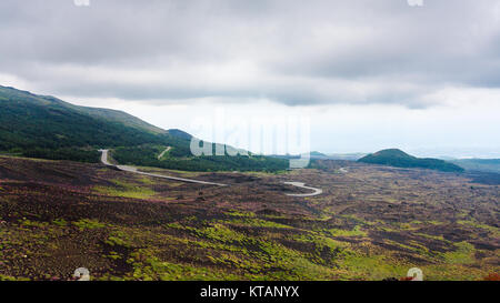 Ciel nuageux sur la route dans des champs de lave sur l'Etna Banque D'Images