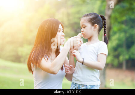 La mère et les filles de manger à l'extérieur du parc. Banque D'Images