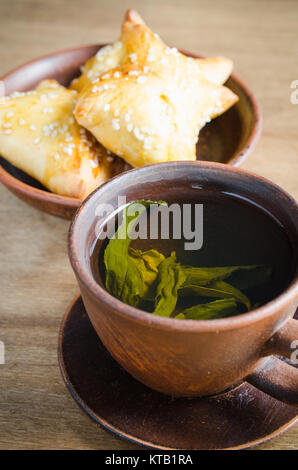 Du thé vert et de pâtés sur table en bois rustique Banque D'Images
