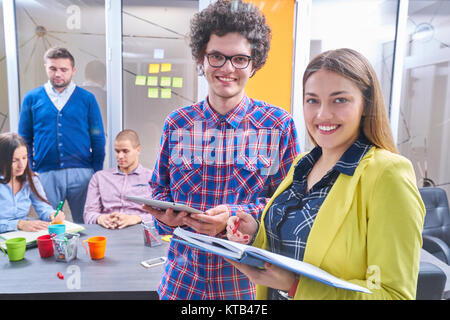 Portrait de groupe de démarrage de créateurs d'une réunion avec un ordinateur portable dans un bureau moderne. Les gens d'affaires ayant conversation détendue plus de nouveaux p Banque D'Images