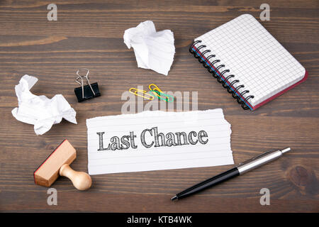 Dernière Chance. le papier feuille à partir de la brochure sur la table en bois. Banque D'Images