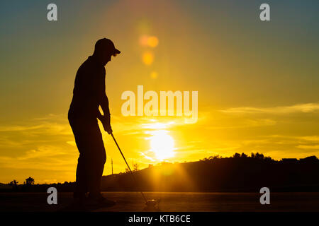Ion Man playing golf la soirée Banque D'Images
