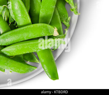 Libre de pois verts en dosettes sur plaque blanche vue de dessus Banque D'Images