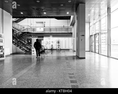 Biella, Italie - 15 décembre 2017 : Un homme attend pour les indications dans les panneaux pour s'orienter à l'intérieur d'un atrium de l'hôpital public de Biella Banque D'Images