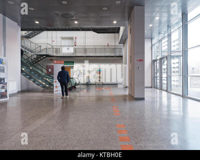 Biella, Italie - 15 décembre 2017 : Un homme attend pour les indications dans les panneaux pour s'orienter à l'intérieur d'un atrium de l'hôpital public de Biella Banque D'Images