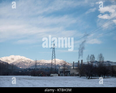 Biella, Italie - 15 décembre 2017 : paysages industriels couverts par la neige au pied des Alpes, l'usine avec des cheminées qui fument la cigarette, dans le pays de Bi Banque D'Images