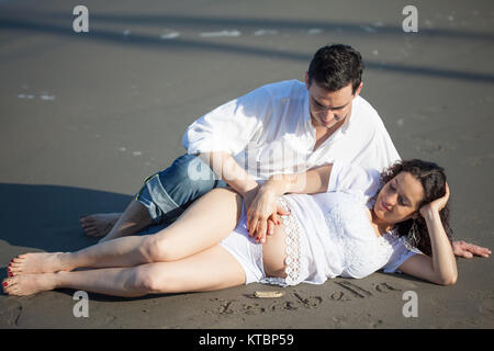 Couple sur la plage en attente de leur bébé - 28 semaines Banque D'Images