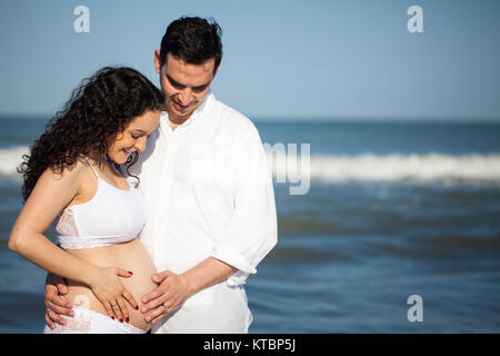 Couple sur la plage en attente de leur bébé - 28 semaines Banque D'Images