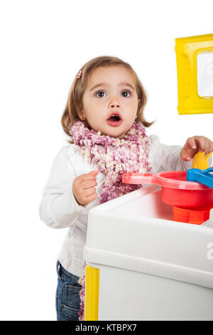 Petite fille blonde jouant avec son jouet cuisine Banque D'Images