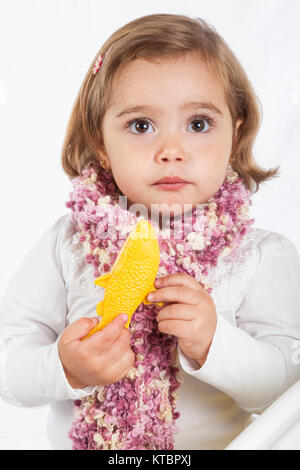 Douce petite fille blonde avec un poisson jaune toy Banque D'Images