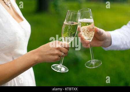 Couple de mariés avec des verres de champagne clink Banque D'Images