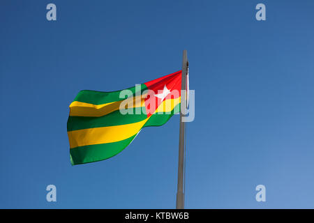 Drapeau national du Togo sur un poteau en face de ciel bleu Banque D'Images