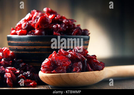 La composition avec bol de canneberges séchées sur table en bois Banque D'Images