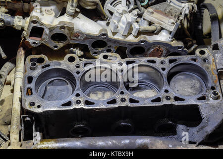 Le carter-cylindres du moteur à quatre cylindres. Véhicule à moteur démonté pour réparation. Les pièces dans de l'huile moteur. Réparation de moteur de voiture dans le service Banque D'Images