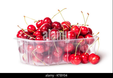 Cerises rouges dans le bac en plastique et une rotation près de trois Banque D'Images