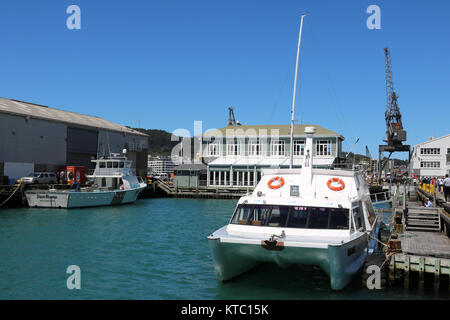 City Cat, à l'Est par West catamaran ferry accoste au Queens Wharf sur le front, Wellington, Nouvelle-Zélande avec Dockside Restaurant et bar derrière. Banque D'Images