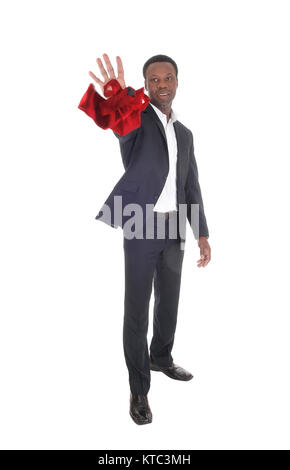 Un grand beau African American man standing dans un costume sombre et jeter sa cravate rouge, smiling, isolée pour fond blanc Banque D'Images