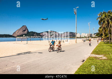 RIO DE JANEIRO, Brésil - le 28 avril 2015 : jeune couple brésilien rides leurs bicyclettes le long de la promenade de la plage de Botafogo le 28 avril 2015 à Rio de Banque D'Images