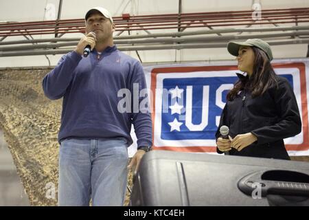Ancien secondeur Brian Urlacher Chicago Bears et actrice Meghan Markle parler aux membres du service au cours de la visite des troupes de l'USO sur scène à Bagram Air Field le 9 décembre 2014 à Bagram, en Afghanistan. Banque D'Images