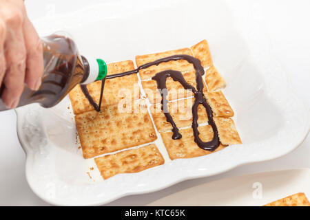 L'ajout d'une sauce au chocolat sur les biscuits pour le dessert de Napoléon Banque D'Images