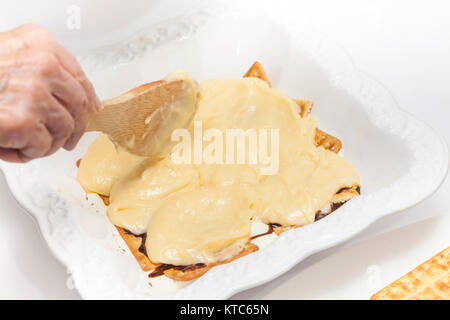 L'ajout de crème anglaise pour le dessert de Napoléon Banque D'Images