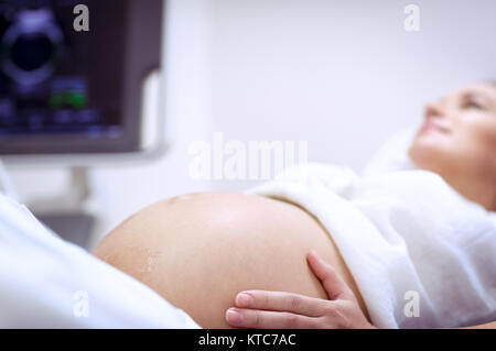 Femme enceinte faire échographie dans la clinique prénatale, mère contrôle de santé de son futur bébé, heureux temps de la grossesse Banque D'Images