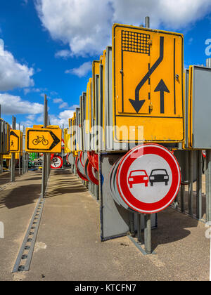 Le rétrécissement de la route jaune et pas de dépassements signe parmi d'autres lignes de signalisation routière attendent d'être embauchés dans des projets de construction de routes Banque D'Images