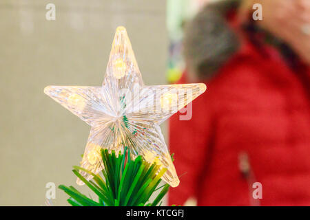 Arbre de Noël étincelante toy star russe à cinq branches sur le dessus de l'arbre de Noël artificiel. Banque D'Images