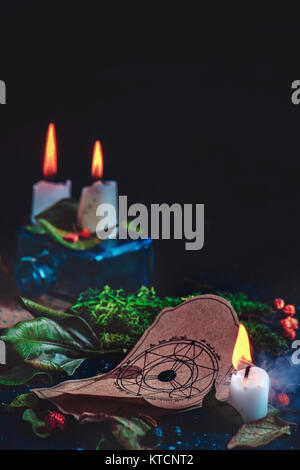 La vie toujours magique avec des bougies allumées, des herbes, des ingrédients de potion et d'un pentagramme dessin sur un parchemin. La sorcellerie moderne concept avec copie espace. Banque D'Images