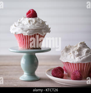 Cupcakes rose framboise fraîche à garnir d'être servi à partir d'un mini plat à gâteau. Sur un fond blanc. Copier l'espace. Banque D'Images