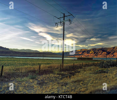 Poteau télégraphique dans le Wyoming paysage avec ciel dramatique au-dessus de terres agricoles clôturé, Wyoming, United States of America Banque D'Images