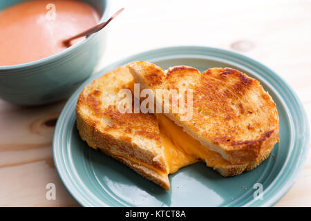 Sandwich au fromage chaud avec un bol de soupe à la tomate. Banque D'Images