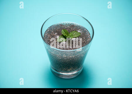 Verre d'eau avec une tasse de graines de chia sain et cuillère. L'espace du texte. Banque D'Images