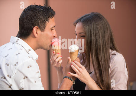 Cheerful couple eating ice cream cones Banque D'Images