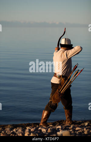 Akynov Almaz, chef du groupe de chasse traditionnel Fédération Salburuun, pose pour des photos sur la rive du lac de Issyk-Kol. Banque D'Images