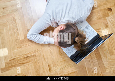 Une femme dort sur l'ordinateur portable. Banque D'Images