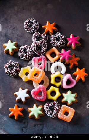 Confiserie gélifiée, de couleur cannelle étoiles et d'autres cookies de Noël sur la masse sombre Banque D'Images