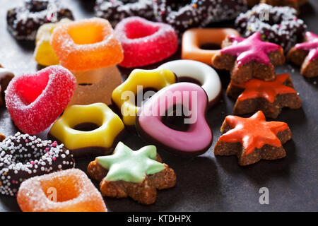 Confiserie gélifiée, de couleur cannelle étoiles et d'autres cookies de Noël sur la masse sombre Banque D'Images