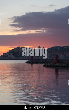 Les nuages colorés spectaculaires au coucher du soleil avec cityscape silhouette. Imperia, Italie Banque D'Images