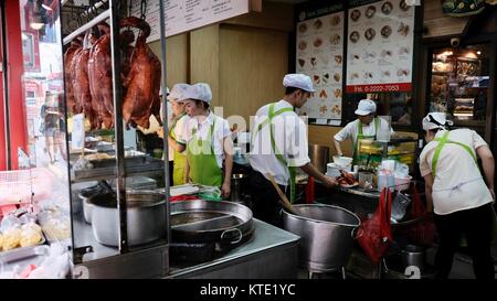 Cuisiniers cuisinant dans la cuisine extérieure sur Yaowarat Road à l'entrée principale du restaurant Hua Seng Hong, Chinatown Bangkok Thaïlande Banque D'Images