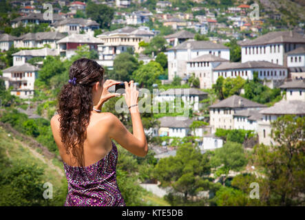 Belle Femme prenant une photo de maisons traditionnelles à Saranda, Albanie. Banque D'Images