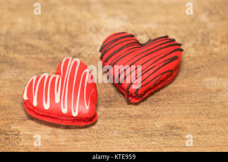 Deux macarons en forme de cœur, assaisonnés de chocolat fait pour la Saint-Valentin Banque D'Images