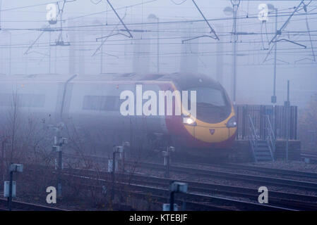 Pendolino Virgin train électrique dans la brume à Warrington Bank Quay station. Banque D'Images